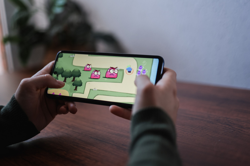 Gamer playing online video games on mobile phone app